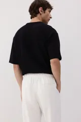 Pantalón blanco de lino con corte recto, cintura elástica y cordón ajustable.