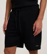 Bermuda masculina de corte slim fit, color marrón, confeccionada en algodón con felpa. Presenta cintura elástica con cordón ajustable y bolsillos laterales.