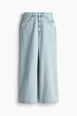 Pantalón jean de tiro bajo en denim bouclé celeste, de algodón rígido, con cinco bolsillos, cierre con botón y corte holgado con piernas amplias.