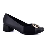 Zapato de cuero negro con taco cuadrado bajo y detalle de elástico en el empeine. Presenta aplique metálico dorado con el logo de la marca.