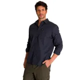 Camisa de popelina verde con cuello abotonado, cierre frontal con botones, bolsillo de parche en el pecho izquierdo, mangas largas con trabillas para enrollar y dobladillo camisero.