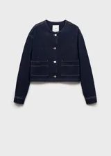 Chaqueta corta de jean azul oscuro, con cuello redondo, cierre frontal con botones y dos bolsillos de parche en la parte delantera.