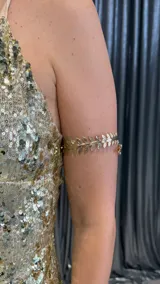 Brazalete dorado para el brazo con diseño de hojas.