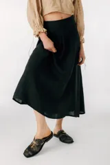 Zuecos negros de cuero con detalle metálico plateado en la tira superior.
