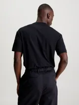 Remera negra de algodón con cuello redondo, mangas cortas y logo Calvin Klein nano en el pecho.
