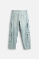 Pantalón cargo de denim color beige, corte relaxed fit, con bolsillos laterales tipo parche con solapa y cierre frontal con botones.