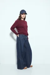 Jean ancho de tiro medio, color azul oscuro, con corte wide leg y paneles de costura visibles en las piernas.