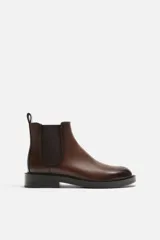 Bota Chelsea marrón de cuero, con elásticos laterales y tirador trasero. Suela negra con ligero tacón.