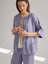 Camisa color coral de lino, corte holgado, escote redondo y mangas 3/4 ajustables con botón.