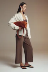 Pantalón culotte color verde oliva, de tiro medio y pierna ancha. Incluye cinturón ajustable con hebilla metálica y cierre lateral con cremallera oculta.