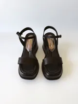 Sandalias negras de cuero con plataforma y pulsera al tobillo.