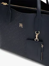 Cartera satchel Tommy Hilfiger color azul marino con monograma TH en relieve. Tiene doble asa de mano, correa bandolera extraíble y monedero extraíble con cremallera.