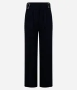 Pantalón recto de punto roma color negro con finas rayas verticales blancas. Tiene cintura alta con hebillas plateadas en los laterales.