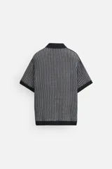 Polo de punto de algodón a rayas verticales en tonos azul marino y gris. Tiene cuello clásico, tapeta con botones y corte recto.