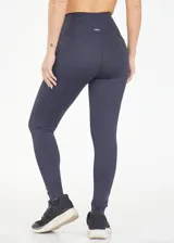 Calza deportiva larga color borgoña, con cintura alta de compresión y tejido transpirable de secado rápido.