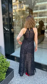 Vestido largo de encaje negro con lurex, cuello halter y tajos laterales. Incluye un vestido corto removible como forro.
