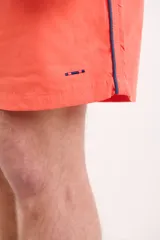 Short de baño azul marino con cintura elástica y cordón ajustable. Detalle de ribete blanco en el lateral.