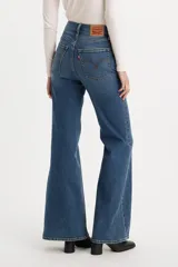 Pantalón de jean acampanado azul, de tiro alto y corte ajustado en la cadera.