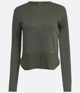 Blusa de viscosa color verde militar, de manga larga y cuello redondo. Presenta corte peplum con volado en el bajo y textura acanalada.