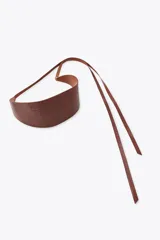Cinturón tipo fajín de cuero color marrón con detalle de flores labradas. Cierre ajustable con lazada en el mismo material.
