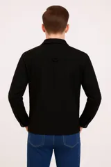 Sobrecamisa color beige con cuello clásico, cierre frontal con botones a tono, mangas largas con puños abotonados, dos bolsillos de parche en el pecho y corte recto.