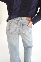 Pantalón de jean color rosa con efecto desgastado, corte recto y tiro medio.