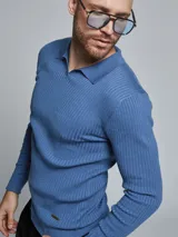 Sweater azul de tejido de punto acanalado, con cuello polo y mangas largas.