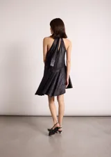 Vestido corto negro con cuello halter y falda con vuelo asimétrico.