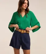 Short clochard azul marino de viscolino con trabillas en la cintura, cinturón con hebilla de madera y pliegues.