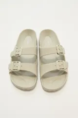 Sandalias tipo Birkenstock color beige con hebillas ajustables.