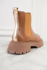Bota Chelsea de cuero color marrón, con elásticos laterales y suela track.