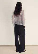 Jersey de punto calado color gris claro, con cuello redondo y manga larga acampanada.