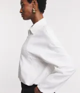 Campera blanca de viscolino, modelo globo, con cuello camisero, manga larga, cierre delantero y bolsillos fake.