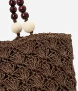 Bolso de mano tipo tote, tejido en punto de ganchillo con textura de conchas, color marrón oscuro. Las asas son de cuero o material sintético oscuro, adornadas con cuentas redondas de madera en tonos marrón oscuro, borgoña y crema.