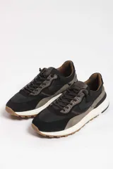 Zapatillas deportivas color beige con detalles en marrón y amarillo.