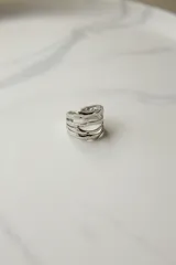 Anillo plateado con detalles dorados, ajustable entre 16 mm y 19 mm, fabricado en acero quirúrgico hipoalergénico.
