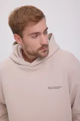 Hoodie color beige de manga larga con capucha, bolsillo tipo canguro, puños de canalé y estampa en la espalda.