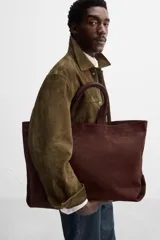 Bolso tipo shopper marrón de piel con acabado serraje. Tiene dos asas de mano y un bolsillo interior con cierre.