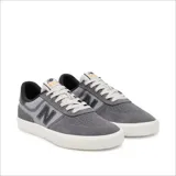 Championes urbanos New Balance modelo NM272LMP, color gris con detalles en negro, confeccionados en gamuza y lona, con logo "N" característico en los laterales y suela blanca.