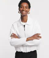 Campera blanca de viscolino, modelo globo, con cuello camisero, manga larga, cierre delantero y bolsillos fake.
