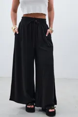 Pantalón palazzo negro de tencel con cintura elastizada y cordón ajustable.