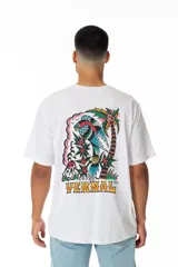 Remera blanca de algodón con estampa en la espalda de un tatuaje tradicional inglés con motivos tropicales: palmera, volcán, loro y flores. Logo frontal VERNAL con tipografía intervenida.