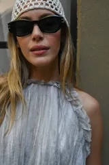 Lentes de sol negros con marco geométrico y patillas gruesas.