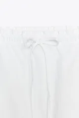 Falda midi blanca de lino, con cintura elástica ajustable con cordones y corte evasé.