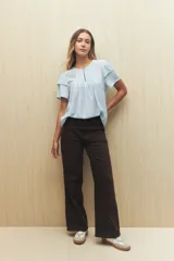 Blusa blanca de tela liviana con mangas cortas con volados y botón de nácar.