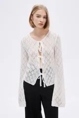 Saco de tejido de punto calado color marfil con escote en V y lazos para atar en el frente.