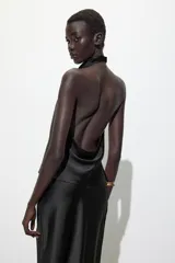 Top color champagne de cuello halter con espalda descubierta y cierre trasero con botones ocultos.