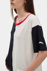Remera oversized colorblock en rib, con mangas cortas y cuello redondo con ribete rojo.