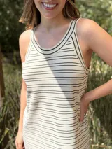 Vestido largo de punto, negro con rayas horizontales blancas, corte recto y sin mangas.