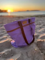 Bolso de lona color negro con detalles en cuero marrón, con bolsillo interno y forro de tela.